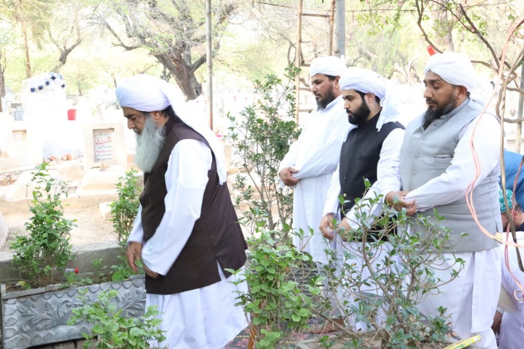 Senior scholar Shaykh Muhammad Mohsin Munawar Yousafi with two younger scholars tending to plants during a Ziyarat (visit) to a sacred graveyard or shrine, symbolizing continuity and spiritual practice.