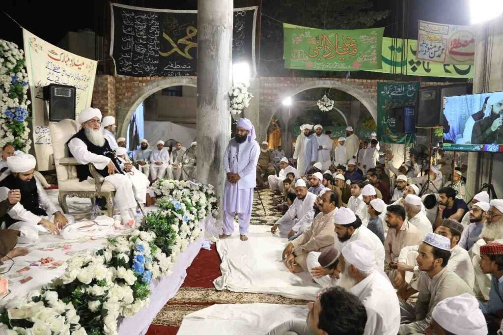 Shaykh Muhammad Mohsin Munawar Yousafi, the esteemed Islamic spiritual guide (Murshid), delivering a passionate discourse, seated and wearing a white turban and dark vest.