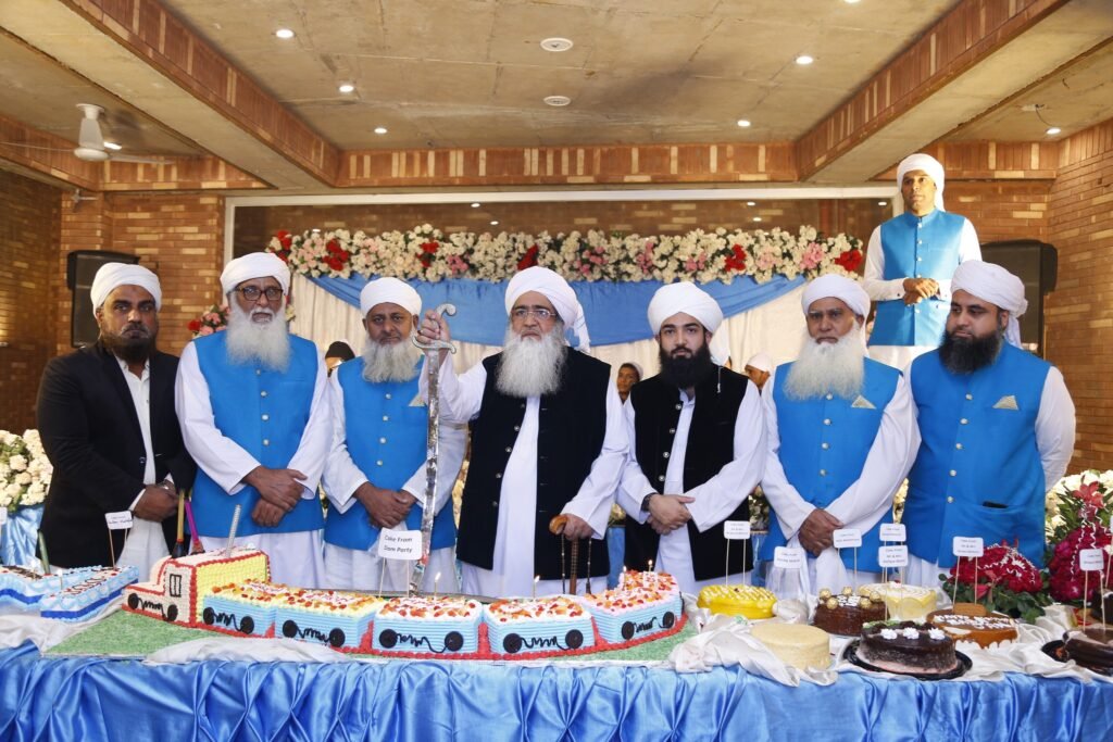 Shaykh Muhammad Bin Mohsin Mohsini and Shaykh Barrister Ahmad Mohsin Mohsini seated on formal chairs, listening to a discourse during an intimate scholarly session (Suhbah) in a drawing room setting.
