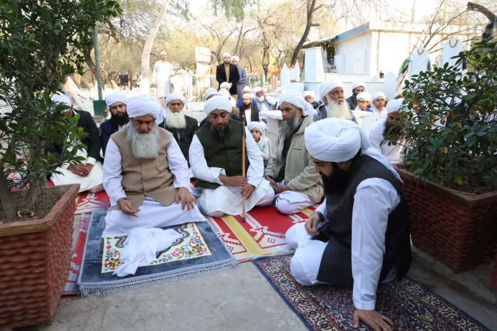 Senior scholar Shaykh Muhammad Mohsin Munawar Yousafi with two younger scholars tending to plants during a Ziyarat (visit) to a sacred graveyard or shrine, symbolizing continuity and spiritual practice.